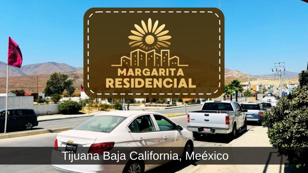 Imagen de la entrada principal de la Comunidad Margarita Residencial en Tijuana, mostrando vehículos estacionados, banderas color rojo y el paisaje montañoso característico de la zona.